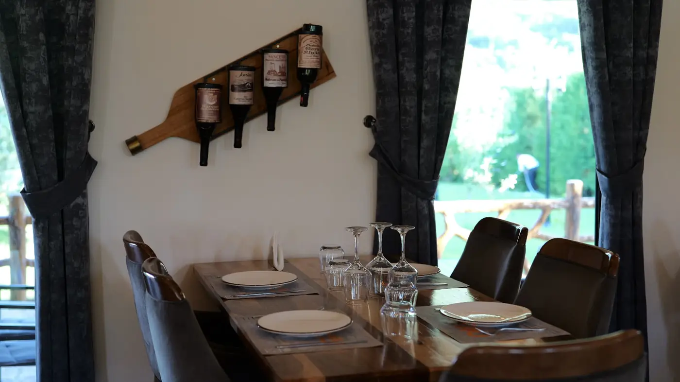 Corner table set for four next to a wooden wine rack