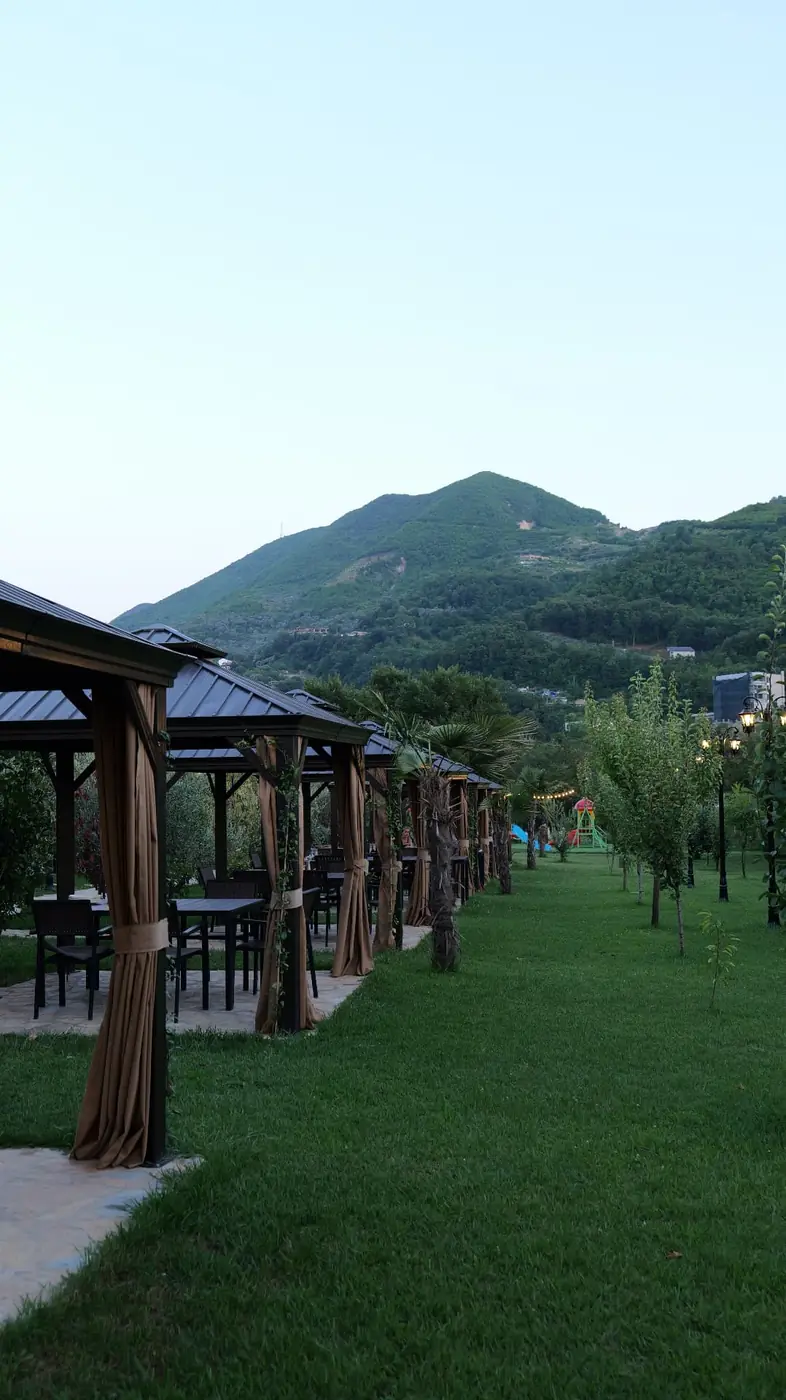 Row of gazebos on the lawn with the green mountain behind OKO Farm