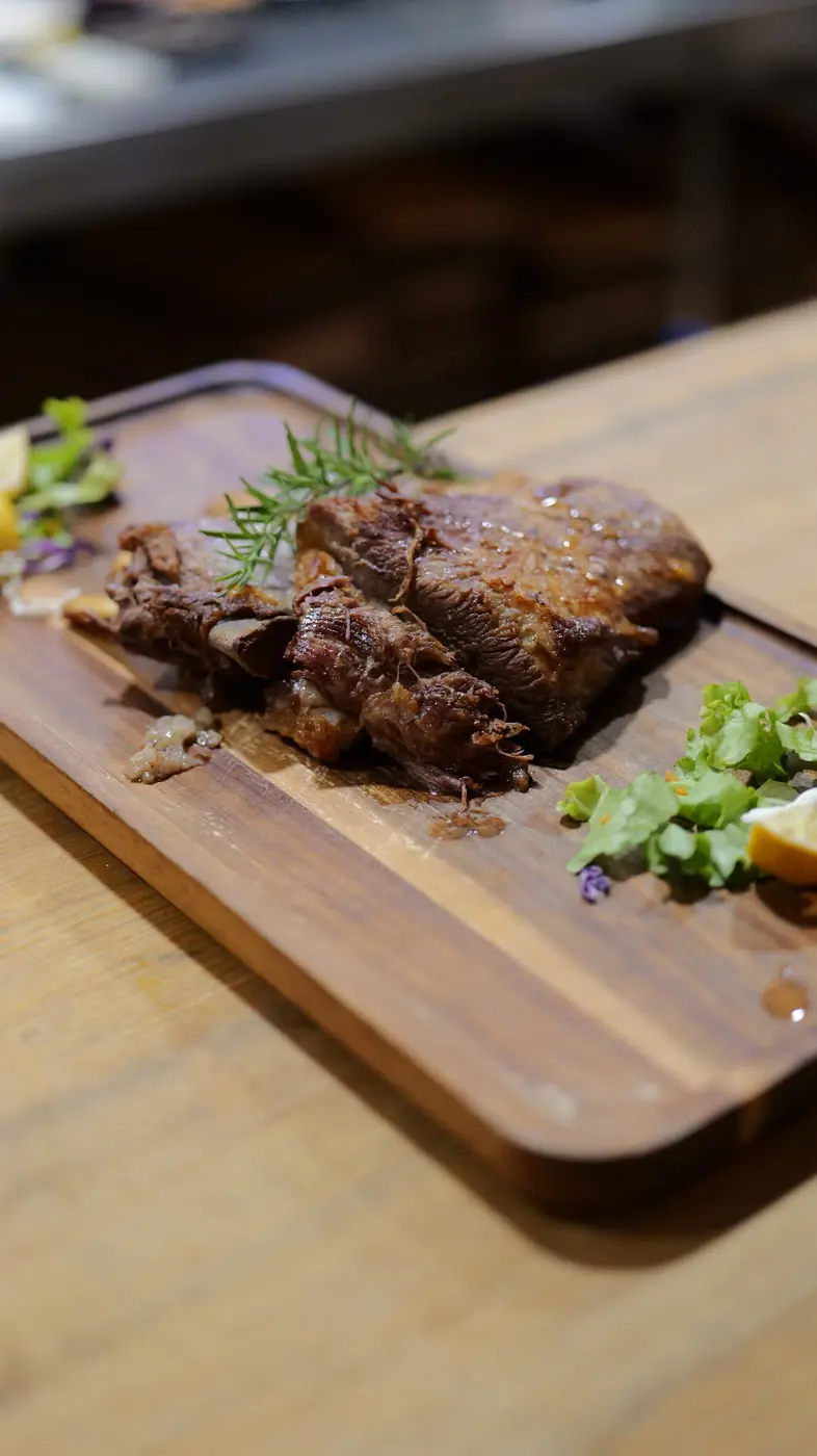 Grilled steak with rosemary and salad on a wooden serving board